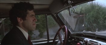 Movie still from “The Long Goodbye” (1973), directed by Robert Altman – A man sitting in the driver's seat of an old car; Close Up shot, Low angle