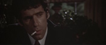 Movie still from “The Long Goodbye” (1973), directed by Robert Altman – A person wearing a suit smoking a cigarette; Close Up shot, Low angle