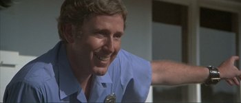 Movie still from “The Long Goodbye” (1973), directed by Robert Altman – A person wearing a shirt and tie smiling; Close Up shot, Low angle