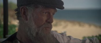 Movie still from “The Long Goodbye” (1973), directed by Robert Altman – An old man with a long white beard wearing a hat; Close Up shot, Over the shoulder angle