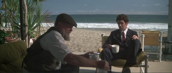 Movie still from “The Long Goodbye” (1973), directed by Robert Altman – Two men sitting on the beach drinking coffee; Wide shot, Over the shoulder angle