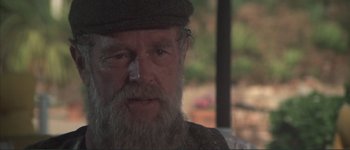 Movie still from “The Long Goodbye” (1973), directed by Robert Altman – An old man with a beard and a hat; Close Up shot, Over the shoulder angle