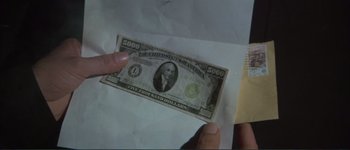 Movie still from “The Long Goodbye” (1973), directed by Robert Altman – A person holding a five hundred dollar bill in their hand; Extreme Close Up shot, Overhead angle