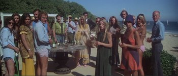 Movie still from “The Long Goodbye” (1973), directed by Robert Altman – A group of people standing around a table with drinks on it; Wide shot, High angle