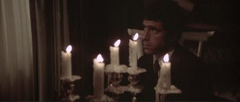 Movie still from “The Long Goodbye” (1973), directed by Robert Altman – A man in a suit and tie looking at candles; Close Up shot, Over the shoulder angle
