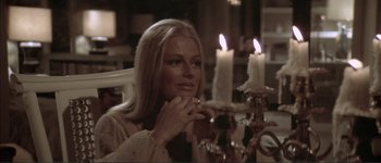 Movie still from “The Long Goodbye” (1973), directed by Robert Altman – A woman sitting in front of a table with candles on top of it; Close Up shot, Over the shoulder angle