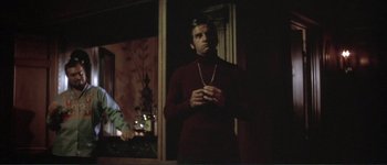 Movie still from “The Long Goodbye” (1973), directed by Robert Altman – A man standing in front of a mirror holding a cell phone; Medium shot, Low angle