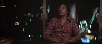 Movie still from “The Long Goodbye” (1973), directed by Robert Altman – A man sitting in front of a window at night; Medium shot, Low angle