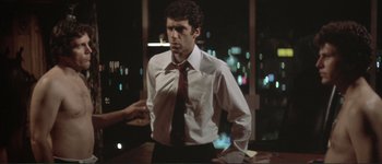 Movie still from “The Long Goodbye” (1973), directed by Robert Altman – A man wearing a white shirt and a red neck tie; Medium shot, Over the shoulder angle