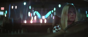 Movie still from “The Long Goodbye” (1973), directed by Robert Altman – A woman sitting in a car at night with lights in the background; Close Up shot, Over the shoulder angle