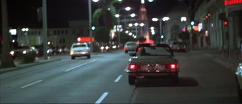Movie still from “The Long Goodbye” (1973), directed by Robert Altman – Cars driving down a street at night with lights on; Wide shot, Low angle
