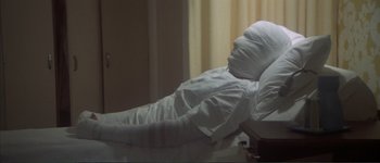 Movie still from “The Long Goodbye” (1973), directed by Robert Altman – A person is lying in a hospital bed; Medium shot, High angle