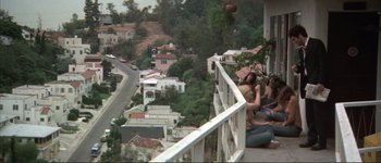 Movie still from “The Long Goodbye” (1973), directed by Robert Altman – Two people are sitting on a balcony looking out over a city; Wide shot, High angle