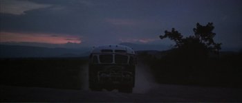 Movie still from “The Long Goodbye” (1973), directed by Robert Altman – A bus driving down a dirt road at night; Extreme Wide shot, Low angle