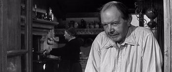 Movie still from “The Longest Day” (1962), directed by Ken Annakin – A black and white photo of a man and a woman in a kitchen; Close Up shot, Over the shoulder angle