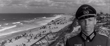 Movie still from “The Longest Day” (1962), directed by Ken Annakin – A black - and - white photo of people on the beach; Close Up shot, Low angle