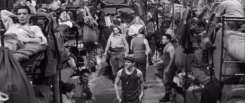 Movie still from “The Longest Day” (1962), directed by Ken Annakin – A black and white photo of a group of men; Wide shot, High angle