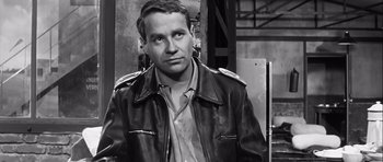 Movie still from “The Longest Day” (1962), directed by Ken Annakin – Black and white photograph of a man wearing a leather jacket; Close Up shot, Over the shoulder angle
