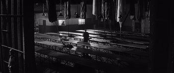 Movie still from “The Longest Day” (1962), directed by Ken Annakin – A man sitting at a table in an empty room; Extreme Wide shot, Low angle