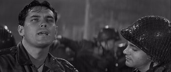 Movie still from “The Longest Day” (1962), directed by Ken Annakin – A black - and - white photo of a man in the rain; Close Up shot, Low angle