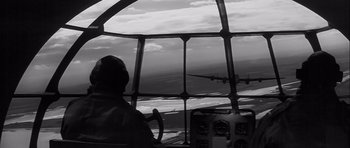 Movie still from “The Longest Day” (1962), directed by Ken Annakin – A man is sitting in the cockpit of an airplane; Wide shot, Low angle