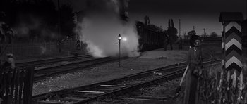 Movie still from “The Longest Day” (1962), directed by Ken Annakin – A train traveling down train tracks next to railroad tracks at night; Extreme Wide shot, Low angle