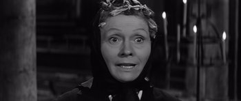 Movie still from “The Longest Day” (1962), directed by Ken Annakin – A black and white photo of a woman with a wreath on her head; Close Up shot, Low angle