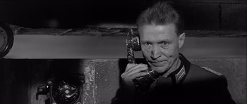 Movie still from “The Longest Day” (1962), directed by Ken Annakin – A black and white photo of a man holding a phone to his ear; Close Up shot, Low angle