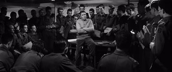 Movie still from “The Longest Day” (1962), directed by Ken Annakin – A group of men sitting around a table; Medium shot, High angle