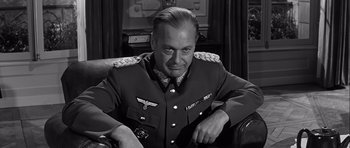 Movie still from “The Longest Day” (1962), directed by Ken Annakin – An older man in a military uniform sitting in a chair; Close Up shot, Over the shoulder angle