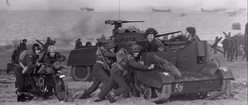 Movie still from “The Longest Day” (1962), directed by Ken Annakin – A black and white photo of men in military uniforms and a tank; Wide shot, High angle