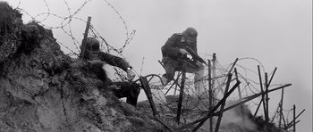 Movie still from “The Longest Day” (1962), directed by Ken Annakin – Two men in uniforms are standing on a hill; Wide shot, Low angle