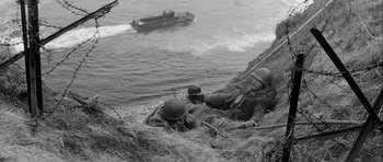 Movie still from “The Longest Day” (1962), directed by Ken Annakin – A black and white photo of soldiers on a beach; Wide shot, High angle