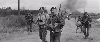 Movie still from “The Longest Day” (1962), directed by Ken Annakin – A group of men walking down a dirt road; Medium shot, Low angle