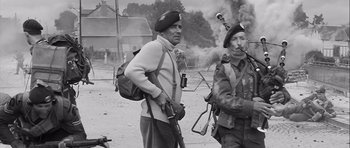 Movie still from “The Longest Day” (1962), directed by Ken Annakin – A black and white photo of two men with guns; Medium shot, Low angle