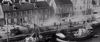 Movie still from “The Longest Day” (1962), directed by Ken Annakin – A black and white photo of a harbor scene with boats and soldiers; Extreme Wide shot, High angle