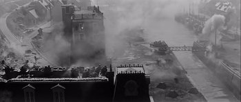 Movie still from “The Longest Day” (1962), directed by Ken Annakin – A black and white photo of a foggy city; Extreme Wide shot, High angle