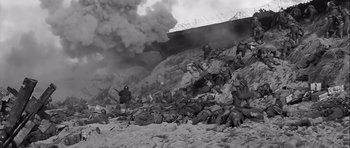 Movie still from “The Longest Day” (1962), directed by Ken Annakin – A black and white photo of a group of soldiers in a field; Extreme Wide shot, High angle