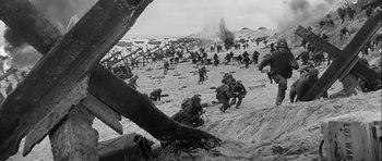 Movie still from “The Longest Day” (1962), directed by Ken Annakin – A black - and - white photo of soldiers on a beach; Extreme Wide shot, High angle