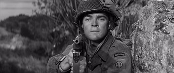 Movie still from “The Longest Day” (1962), directed by Ken Annakin – A man holding a gun while wearing an army uniform; Close Up shot, Low angle
