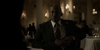 Movie still from “House of Cards” (2013), created by Beau Willimon – A man sitting at a table with a glass of red wine; Close Up shot, Low angle