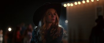 Movie still from “The Longest Ride” (2015), directed by George Tillman Jr. – A woman in a cowboy hat looking to her left; Close Up shot, Over the shoulder angle