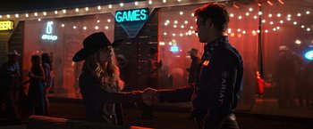 Movie still from “The Longest Ride” (2015), directed by George Tillman Jr. – A man and a woman shaking hands in front of lights; Medium shot, Over the shoulder angle