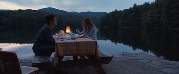 Movie still from “The Longest Ride” (2015), directed by George Tillman Jr. – A man and a woman sitting at a table near a body of water; Wide shot, High angle