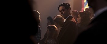 Movie still from “The Longest Ride” (2015), directed by George Tillman Jr. – A group of people standing in a room; Medium shot, Over the shoulder angle