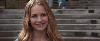 Movie still from “The Longest Ride” (2015), directed by George Tillman Jr. – A person smiling near some stairs; Close Up shot, Over the shoulder angle