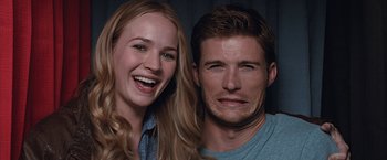 Movie still from “The Longest Ride” (2015), directed by George Tillman Jr. – A man and a woman smiling for the camera; Close Up shot, Low angle