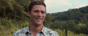 Movie still from “The Longest Ride” (2015), directed by George Tillman Jr. – A person wearing a plaid shirt smiling; Close Up shot, Over the shoulder angle