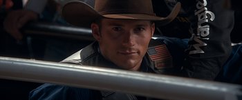 Movie still from “The Longest Ride” (2015), directed by George Tillman Jr. – A man wearing a cowboy hat with an american flag on it's brim; Close Up shot, Over the shoulder angle