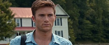 Movie still from “The Longest Ride” (2015), directed by George Tillman Jr. – A person wearing a blue shirt near a house; Close Up shot, Over the shoulder angle
